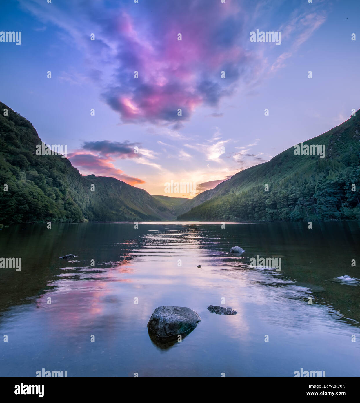 Glendalough, co. Wicklow / Ireland - Beautiful reflection of sky in water of Upper Lake in Glendalough Valley at dusk Stock Photo