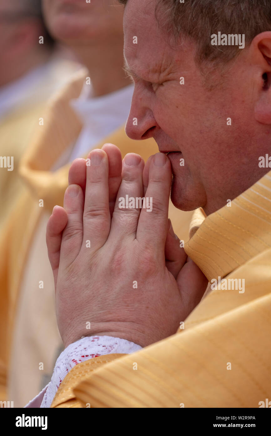 Cleric prays at the Feast of Corpus Christi procession taking place in the streets of Krakow old town, Poland Stock Photo