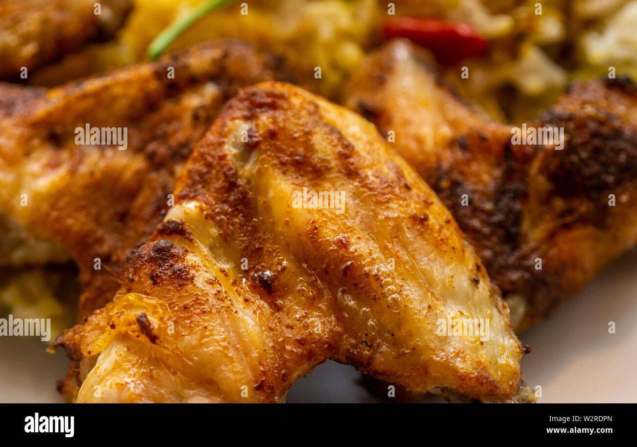 Grilled well seasoned crispy chicken wings closeup, tasty Stock Photo