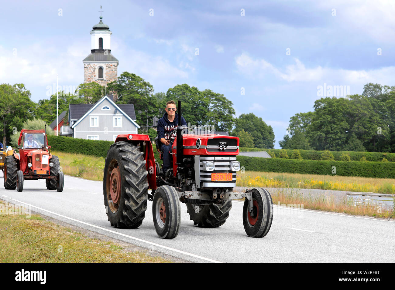Kimito, Finland. July 6, 2019. Young man drives Massey Ferguson 178 Multi-Power tractor on Kimito Tractorkavalkad, vintage tractor show and parade. Stock Photo