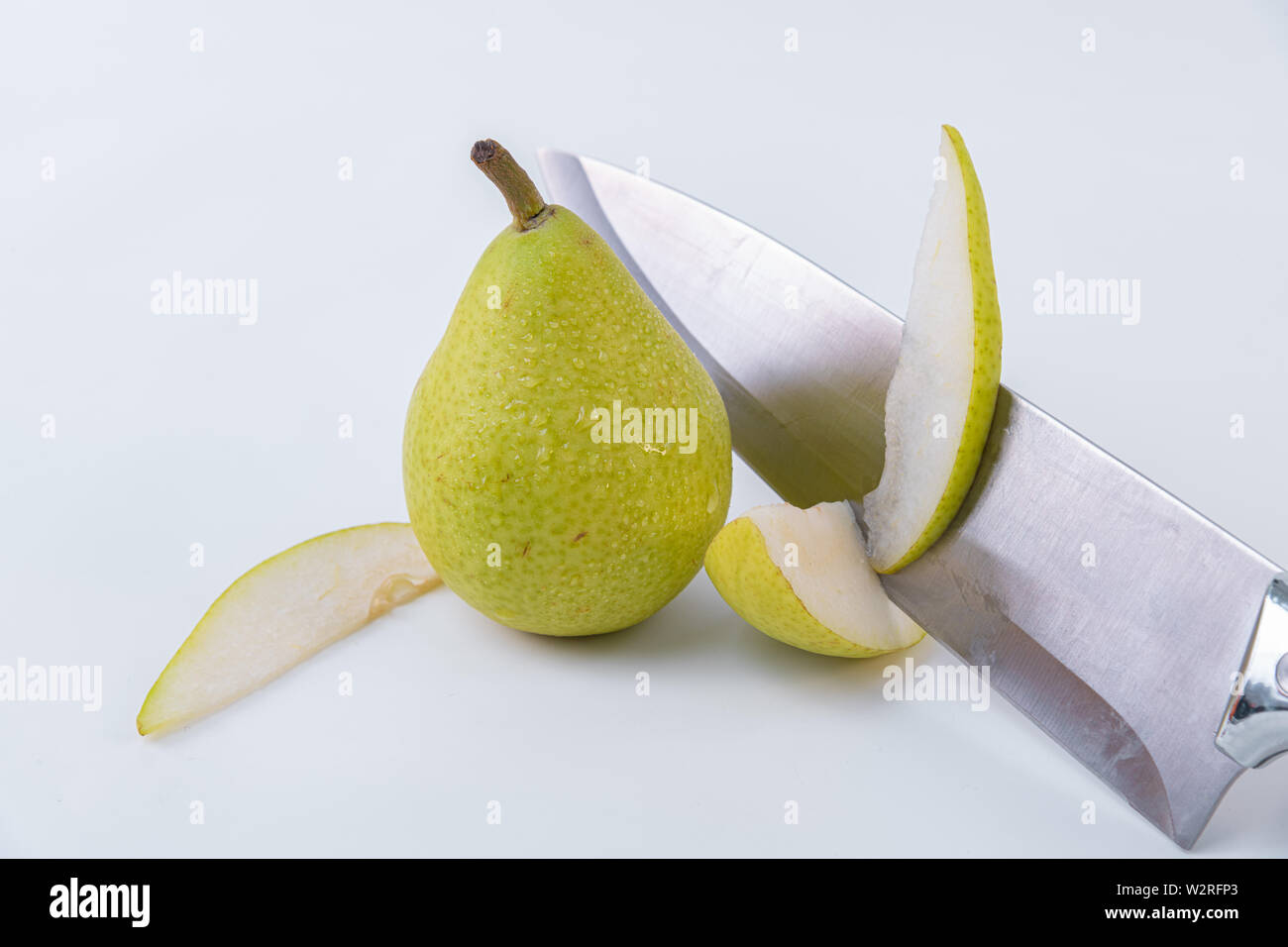 Sweet pear breakfast - A knife cutting a pear - Pear sliced and whole ...
