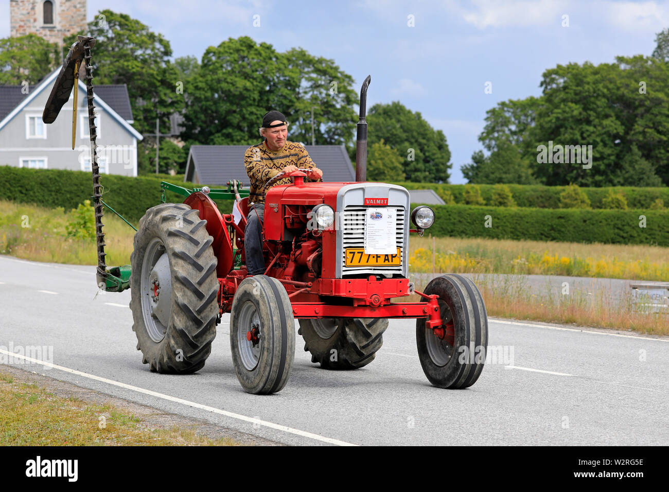 Kimito,Finland. July 6, 2019. Man drives Valmet 361 D tractor, year 1962, in front of farm equipment on Kimito Tractorkavalkad, vintage tractor parade Stock Photo