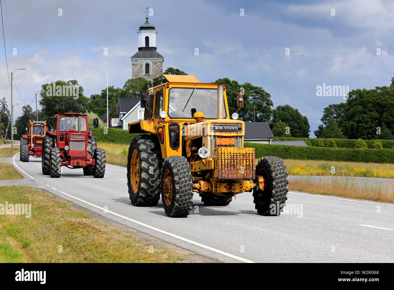 Kimito, Finland. July 6, 2019. Three Volvo BM tractors, yellow 814 first, on Kimito Tractorkavalkad, annual tractor parade through the small town. Stock Photo