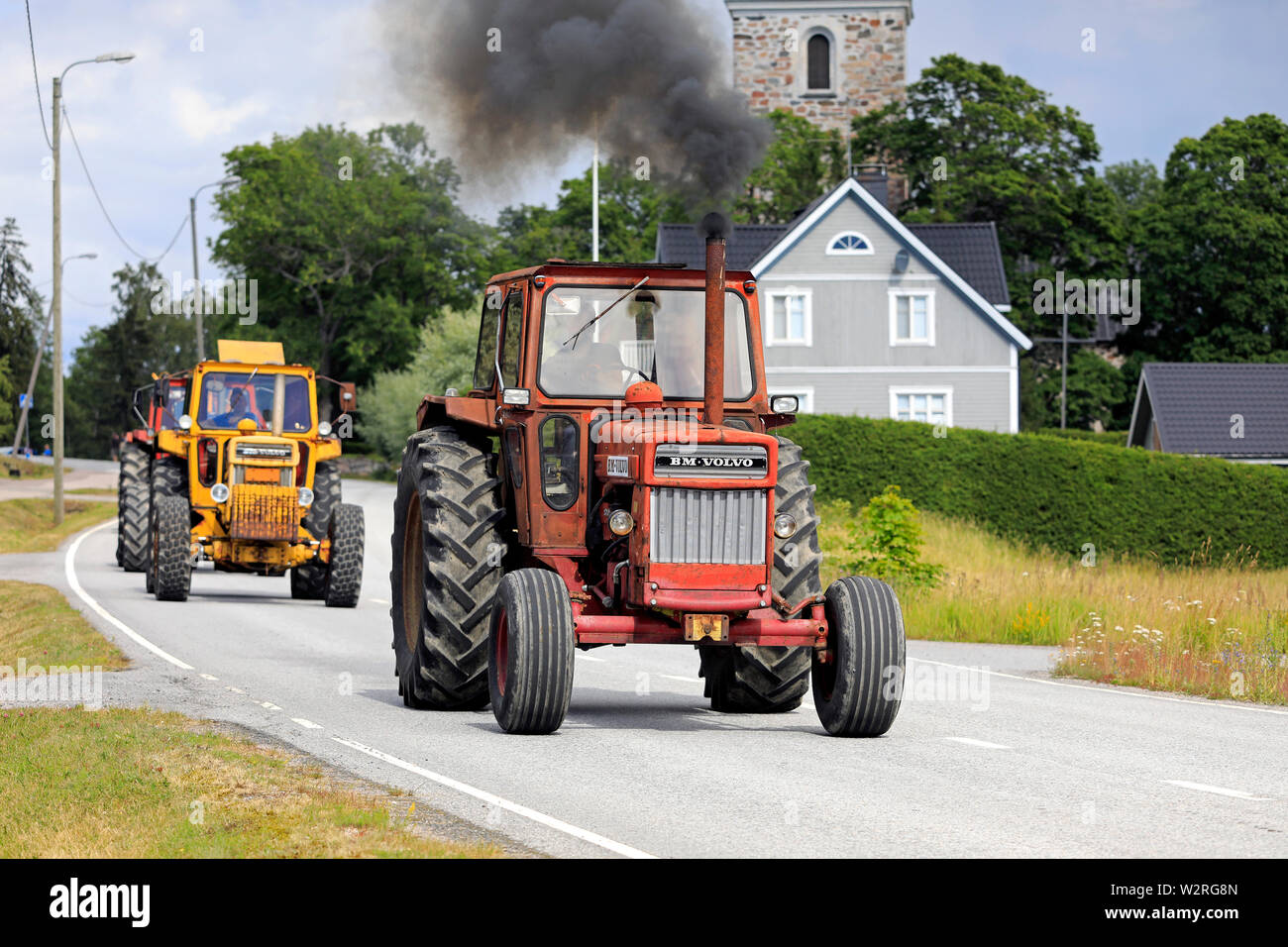 Kimito, Finland. July 6, 2019. Volvo BM tractors, red 810 first, on Kimito Tractorkavalkad, annual tractor parade through the small town. Stock Photo