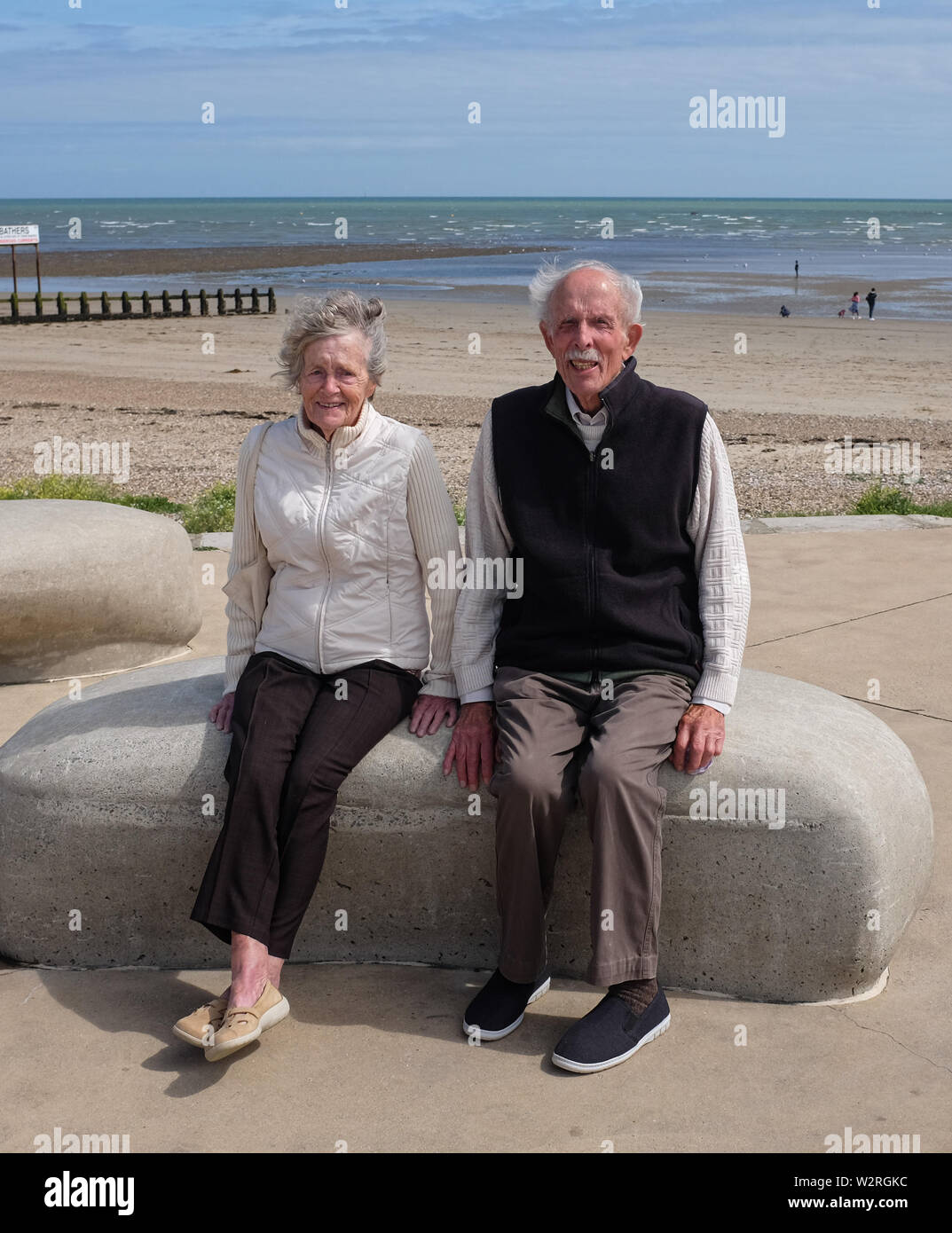Littlehampton West Sussex UK - Elderly couple sitting together on the seafront Stock Photo