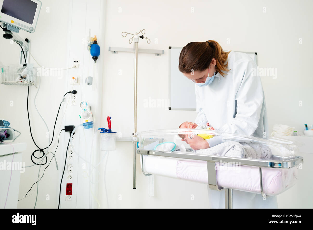 Nurse in ICU examining premature born child Stock Photo - Alamy