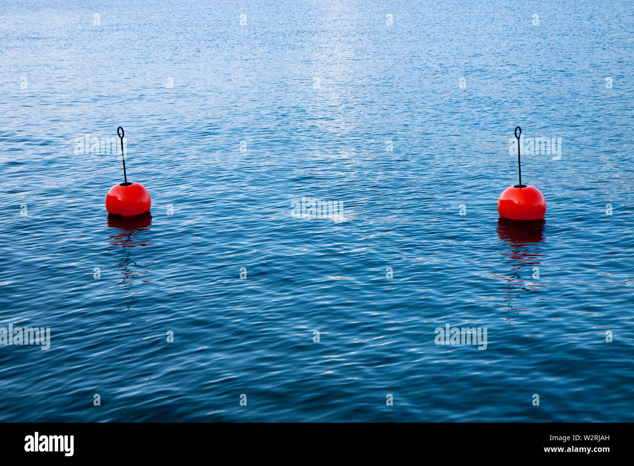 Red bouy on a calm lake isolated on blue background Stock Photo