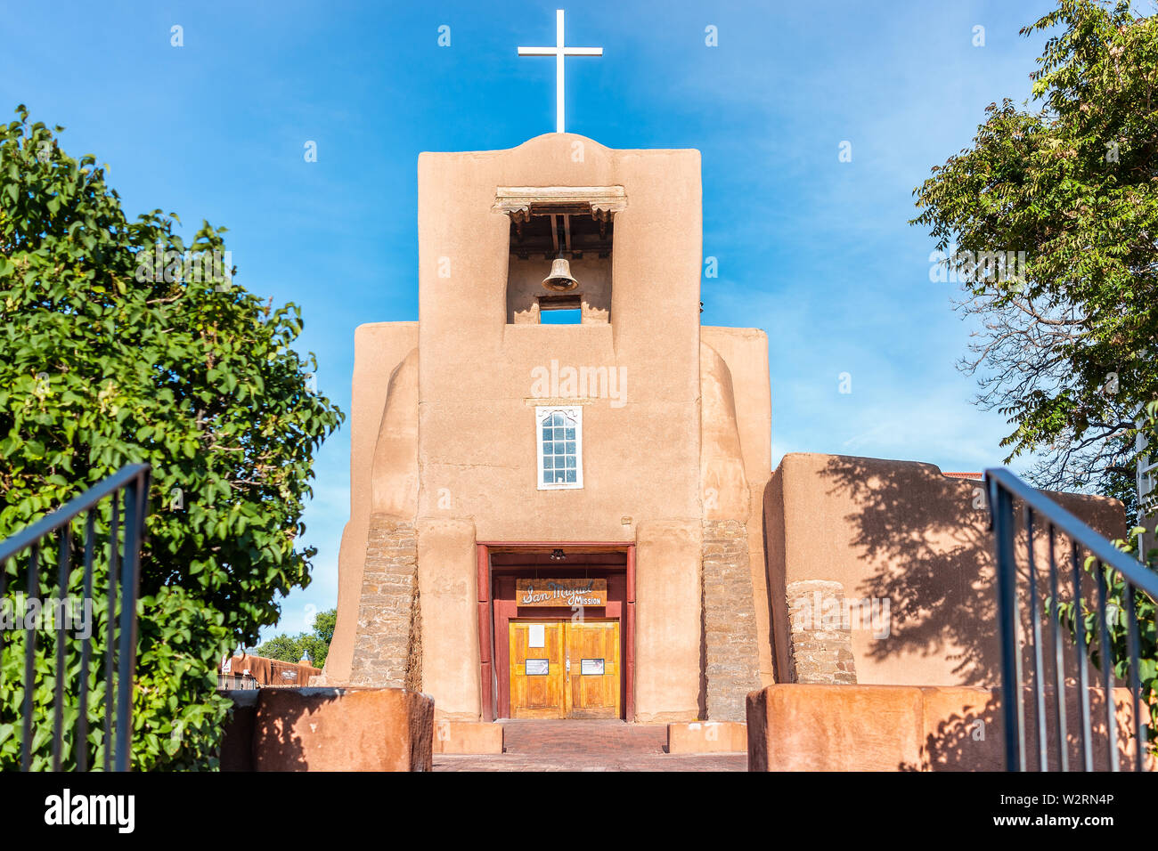 Santa Fe, USA - June 14, 2019: San Miguel Mission chapel oldest church in the United States with adobe pueblan style architecture, blue cross and blue Stock Photo
