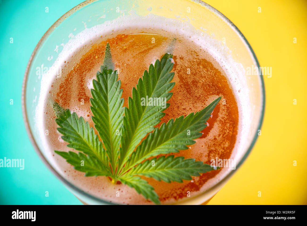 Detail of cold glass of beer with cannabis leaf, marijuana infused beverage concept Stock Photo