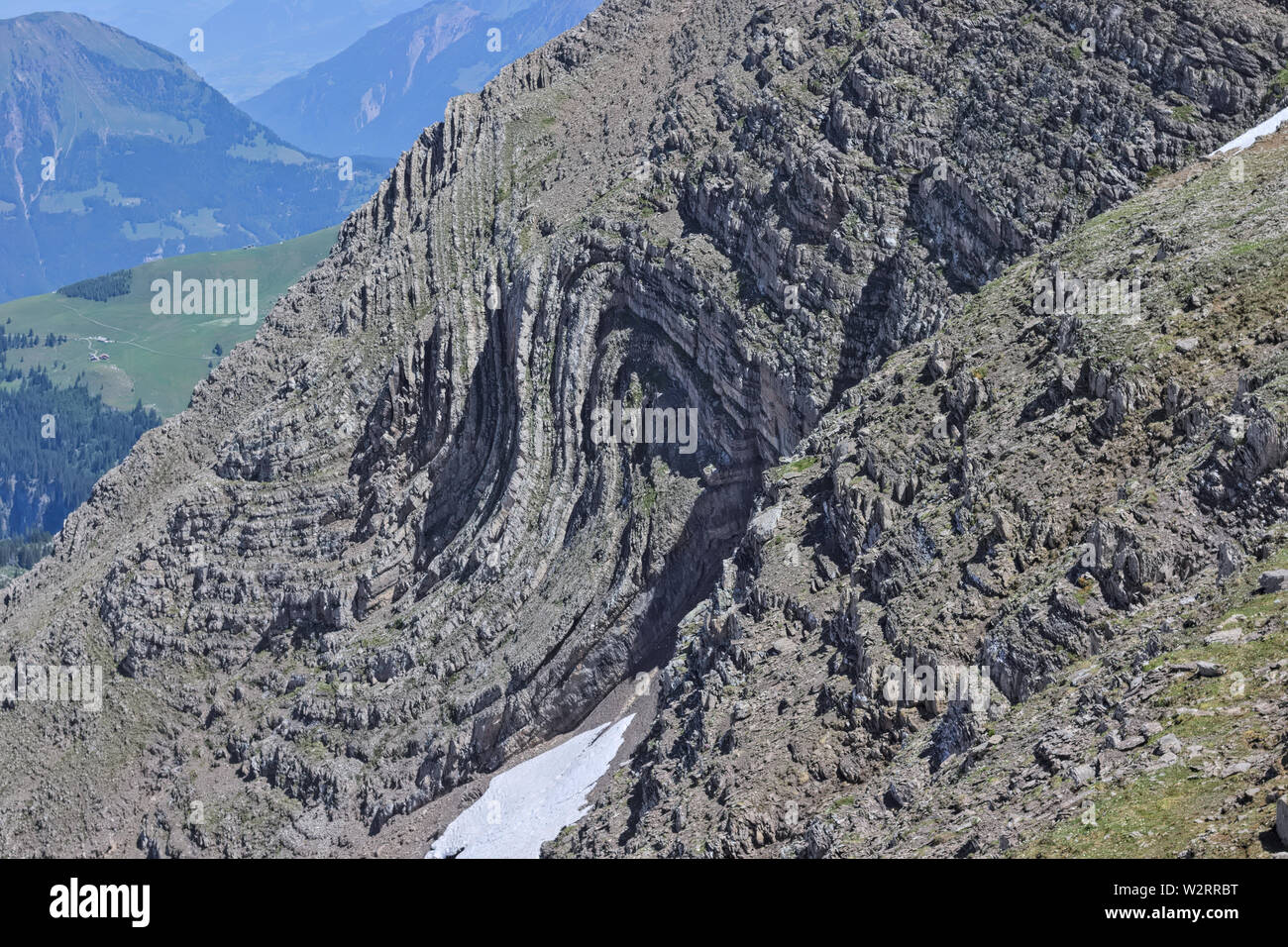 Rock folded into syncline in alpine swiss mountains. S-Fold found at steep mountain side. Stock Photo