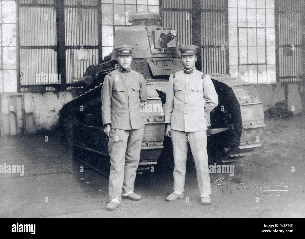 [ 1930s Japan - Japanese Soldiers and French Tank ] —   Two Japanese soldiers stand in front of a French Renault FT-17 light infantry tank, one the most revolutionary tank designs in history.   Japan imported 13 FT-17's in 1919 (Taisho 8), which were used in the Manchurian Incident (1931-1932) and for training. The French guns were replaced with Japanese armament.  20th century vintage gelatin silver print. Stock Photo