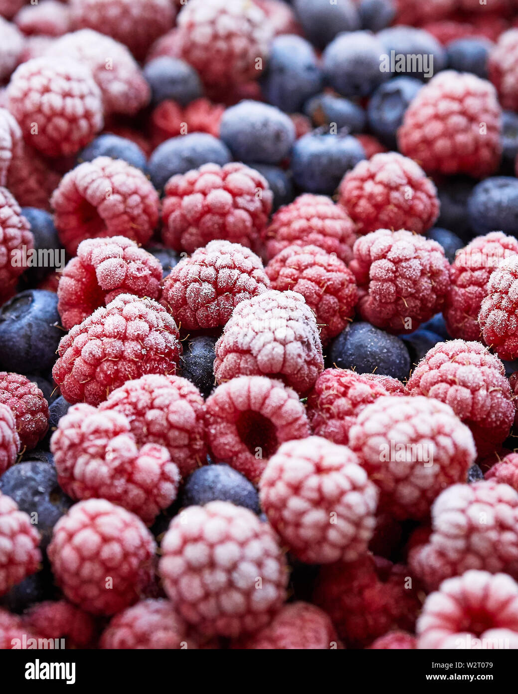 Background of frozen berries. Top view of raspberries and blueberries. Stock Photo