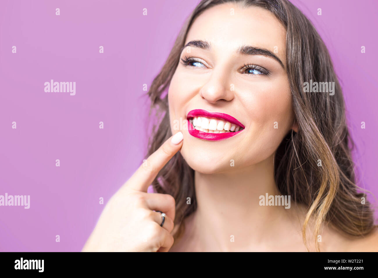 Dentistry concept. Beautiful young woman smiling, showing healthy white teeth, red lipstick. Stock Photo
