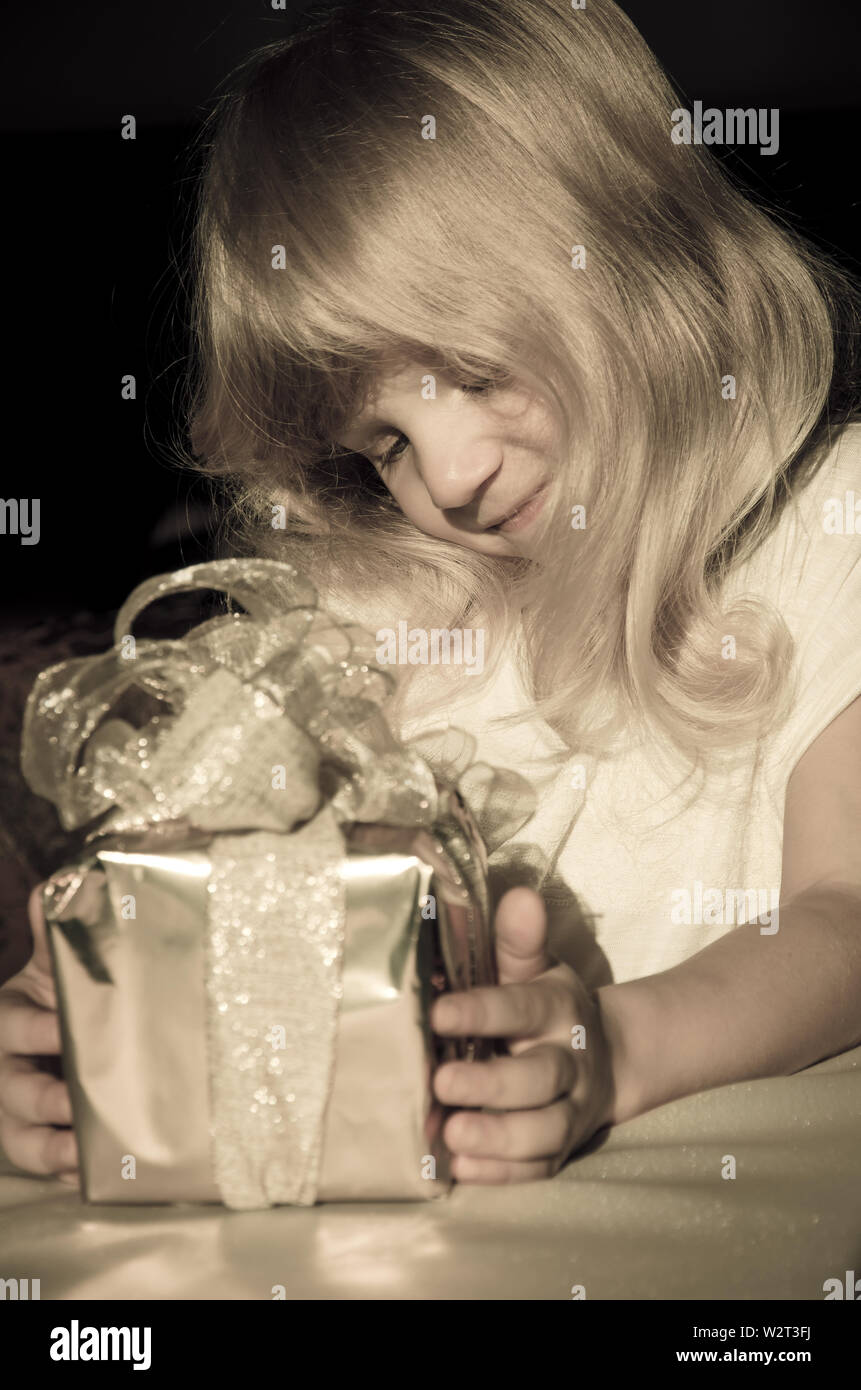 beautiful blond girl with gift in hands Stock Photo