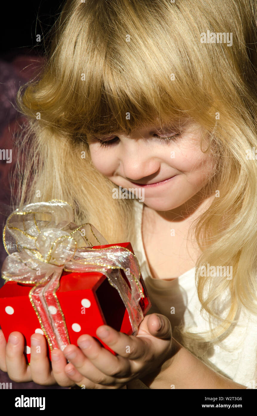 beautiful blond girl with red gift in hands Stock Photo