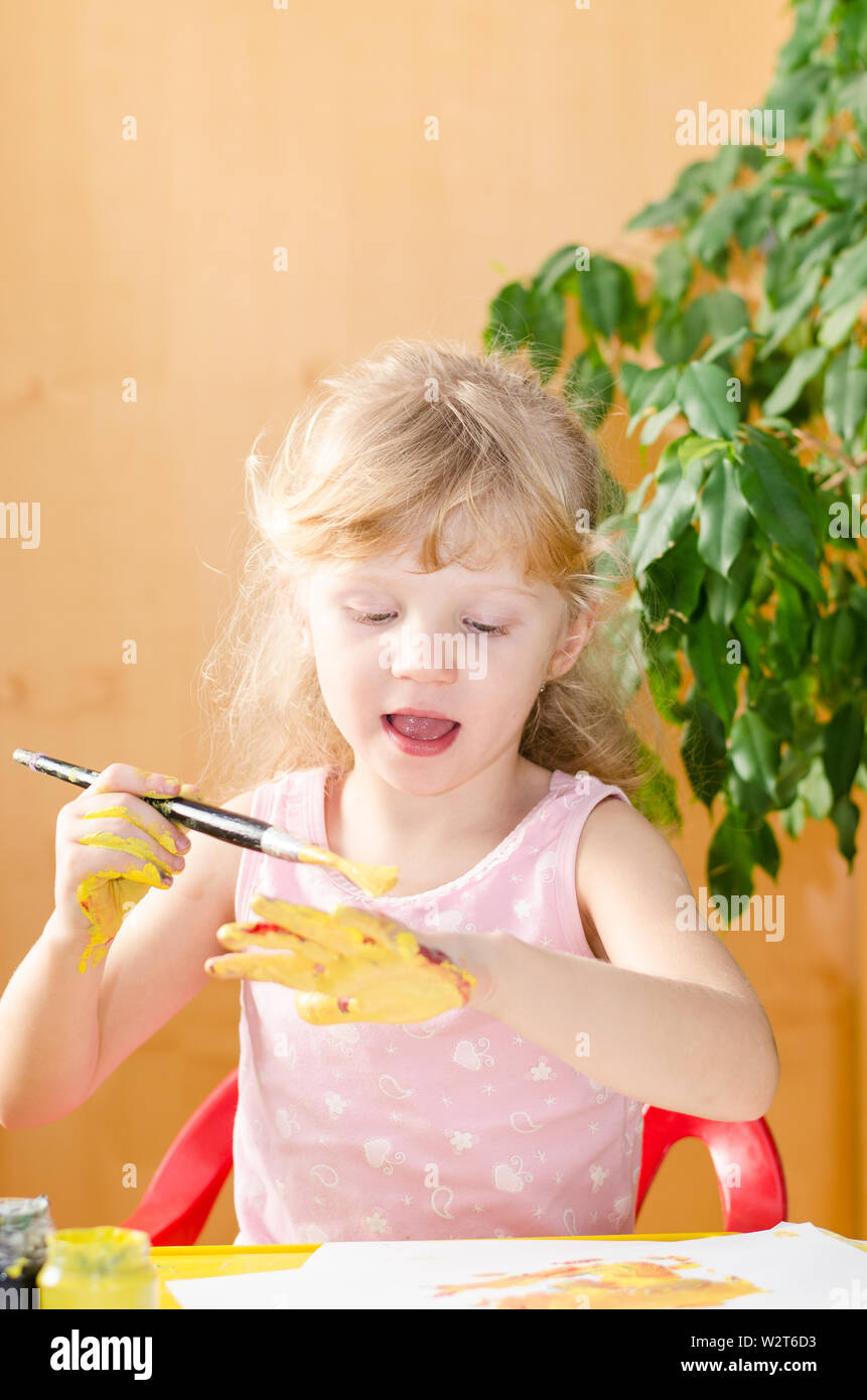 blond girl painting with brush her hand Stock Photo Alamy