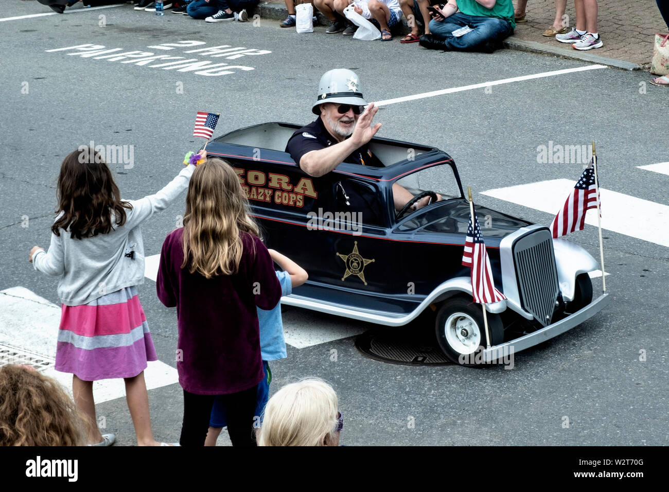 A Shriner rides a mini car past spectators during the Windjammer Days parade in tiny midcoast hamlet of Boothbay Harbor, Maine. Stock Photo