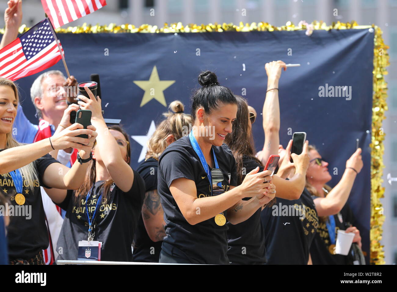 NEW YORK, NEW YORK - JUNE 30: Ali Krieger takes photos of the crowds as the U.S. women's soccer team is celebrated along the Canyon of Heroes. Stock Photo