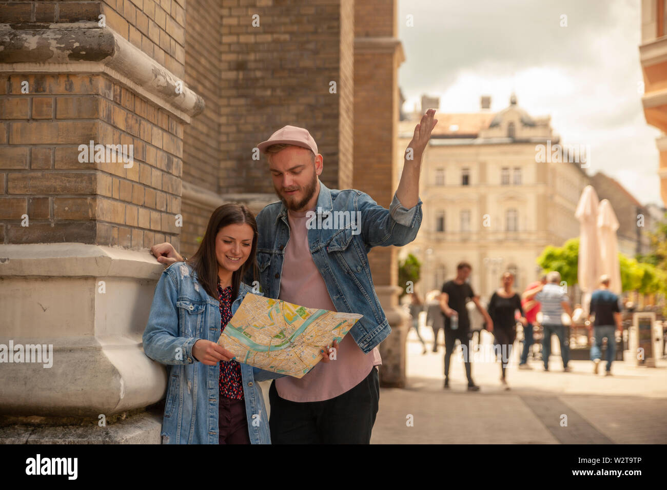 two friends, or couple, discussing while looking at a city map while one man is pointing finger. Location Novi Sad, Serbia. Stock Photo
