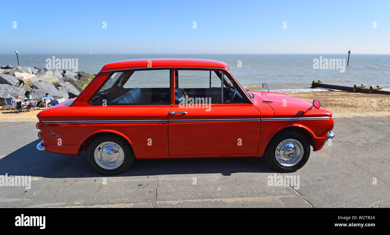 Classic Red Hillman Imp Motor Car parked on seafront promenade. Stock Photo