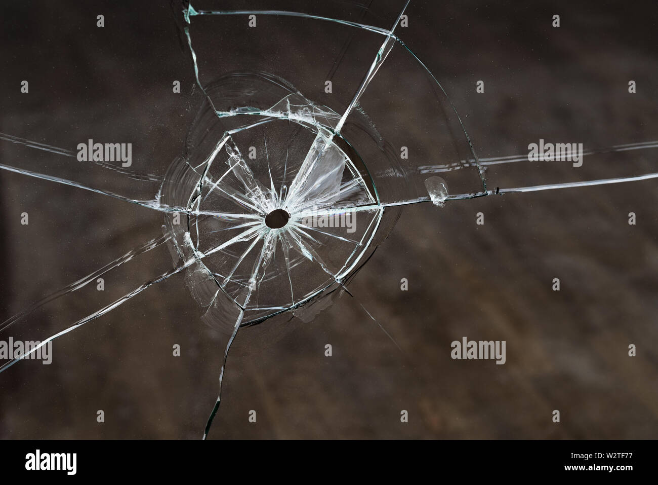 Trace from the bullet after the shot. Broken glass with cracks. Concept for design Stock Photo