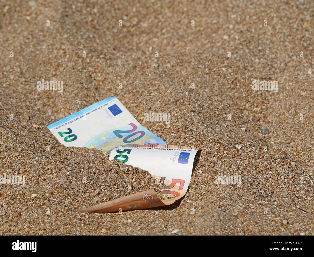 fifty and twenty euro banknote in sand on the beach with copy space Stock Photo