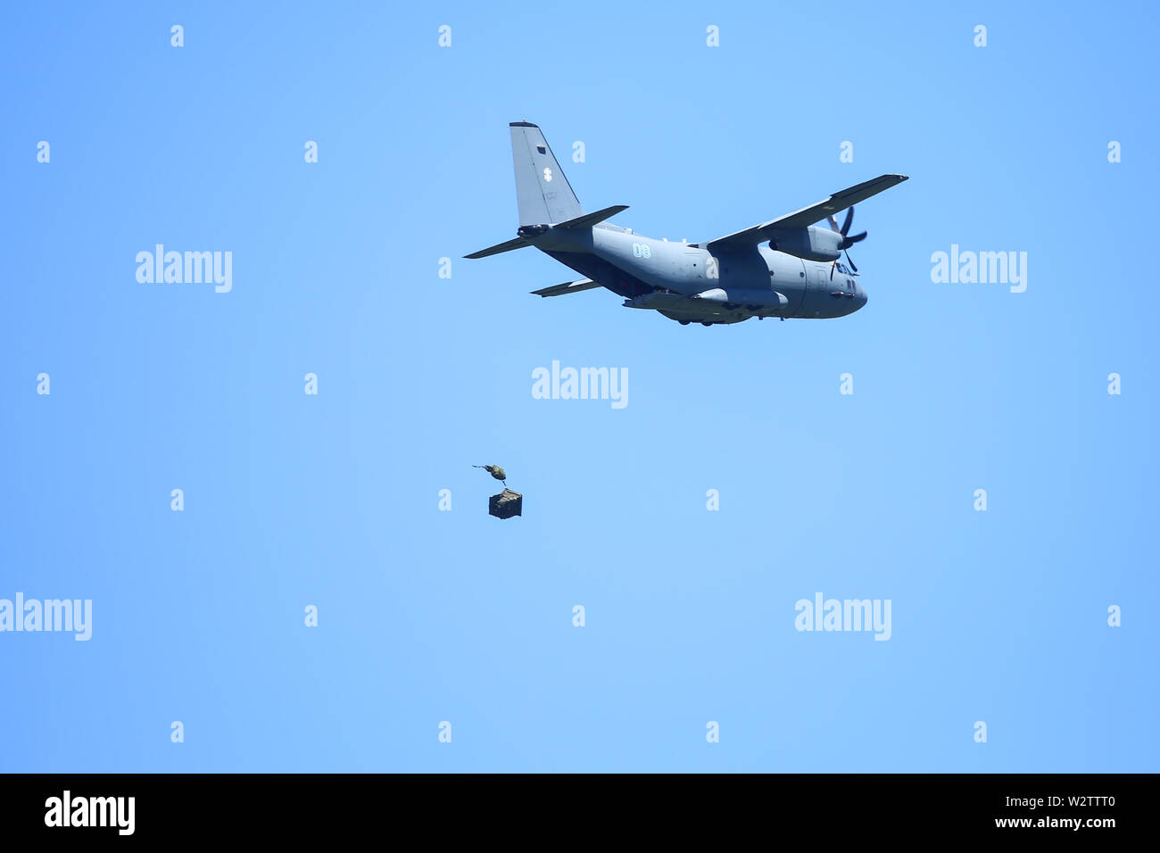 Boboc, Romania - May 22, 2019: A military crate is being parachuted from an Alenia C-27J Spartan military cargo plane during a drill. Stock Photo