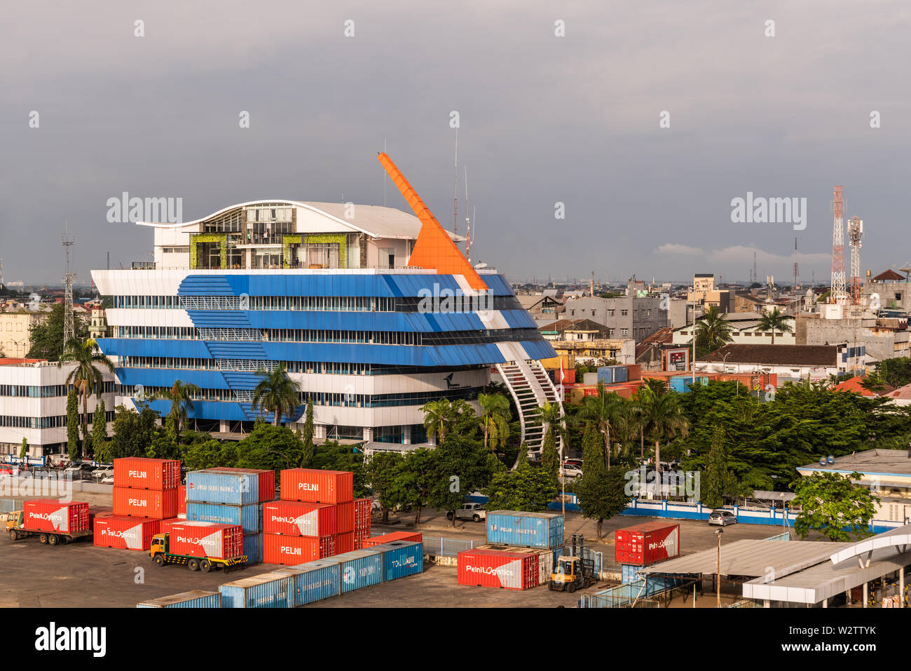 Makassar, Sulawesi, Indonesia - February 28, 2019: Blue, white and orange building named Complex PT Pelindo IV in the harbor under cloudscape. shippin Stock Photo