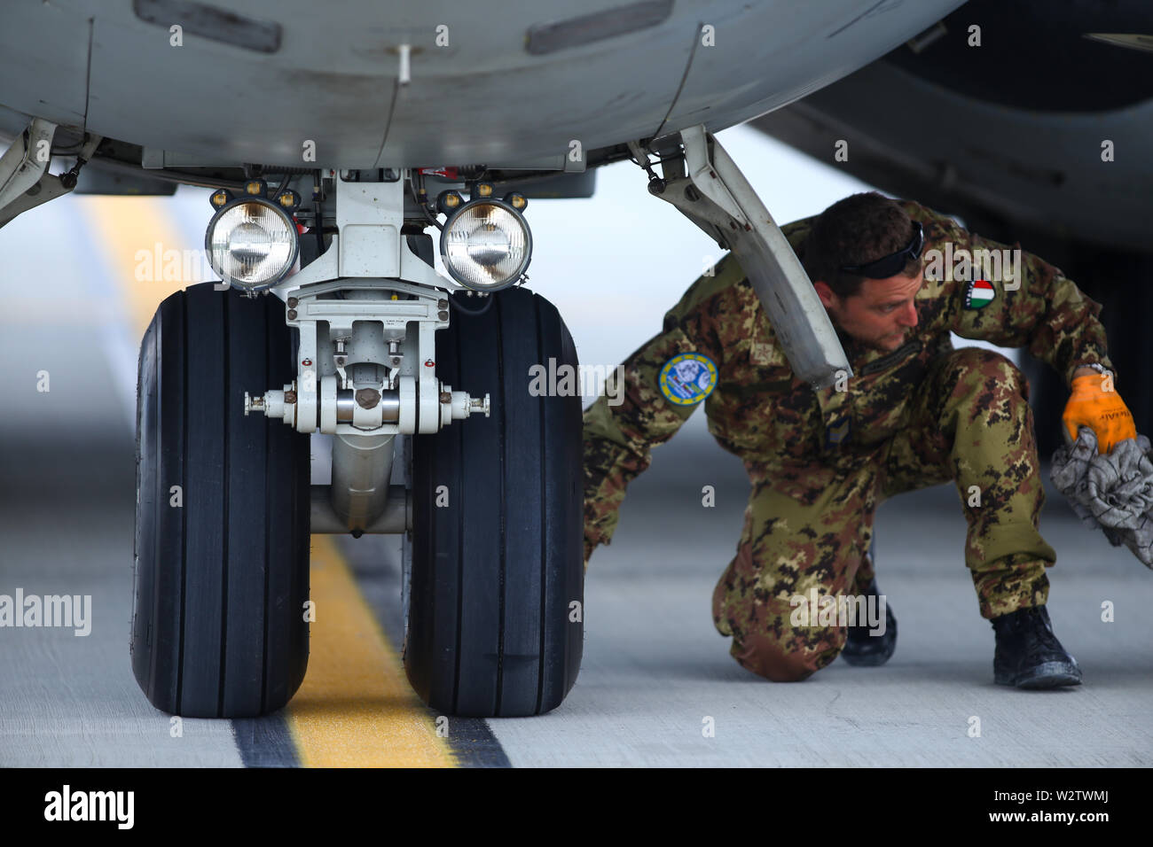 Otopeni, Romania - May 22, 2019: A mechanic is inspecting parts of an Alenia C-27J Spartan military cargo plane after landing on an airbase. Stock Photo