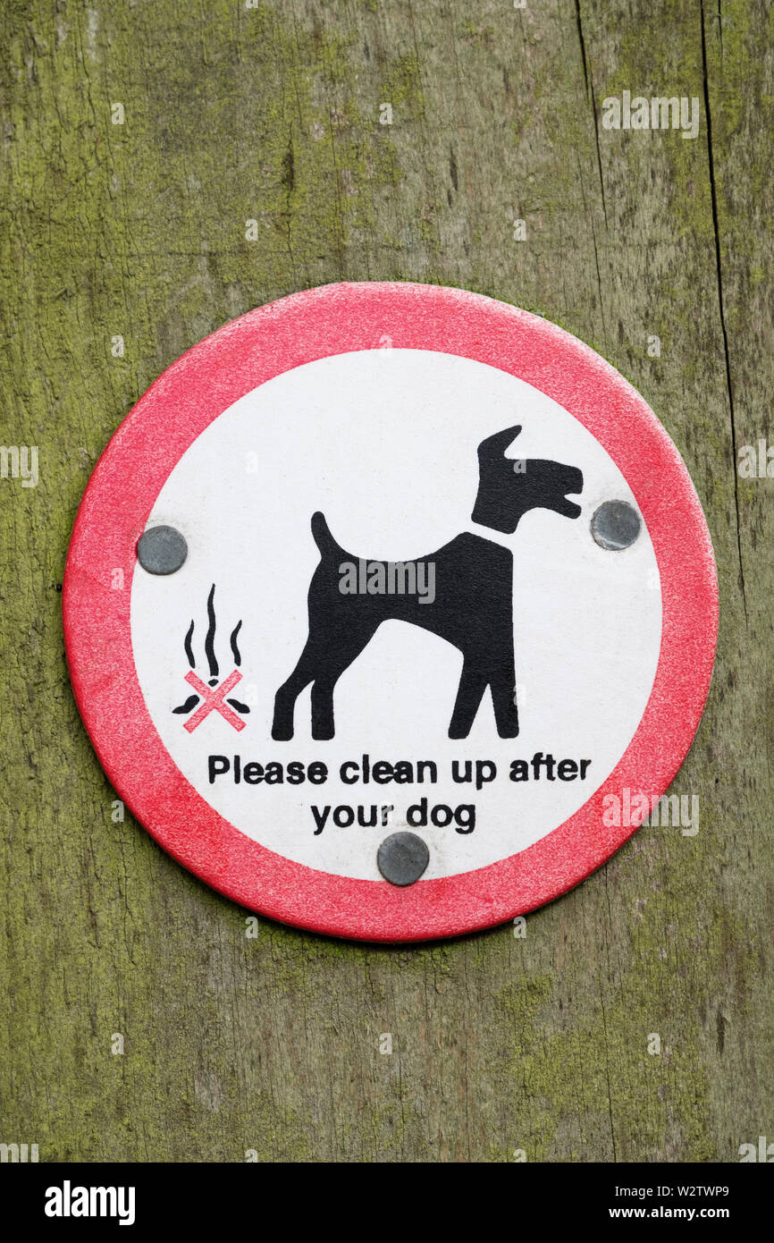A sign asking dog walkers to clean up after their dogs. Stock Photo