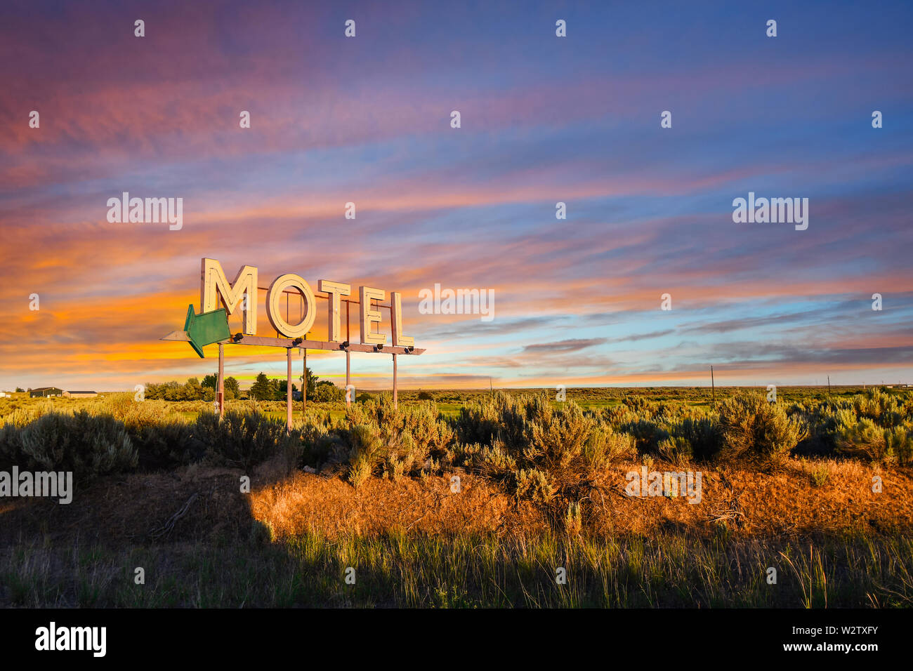 Vintage roadside highway Motel advertising sign seen through a colorful sunset in the American Desert of the Inland Northwest. Stock Photo