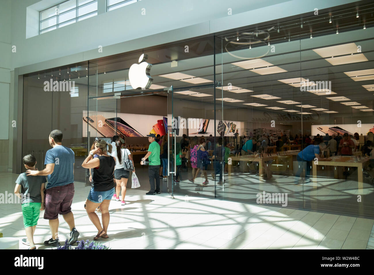 people walking past the apple store at The Florida Mall enclosed shopping  mall orlando Florida USA United States of America Stock Photo - Alamy