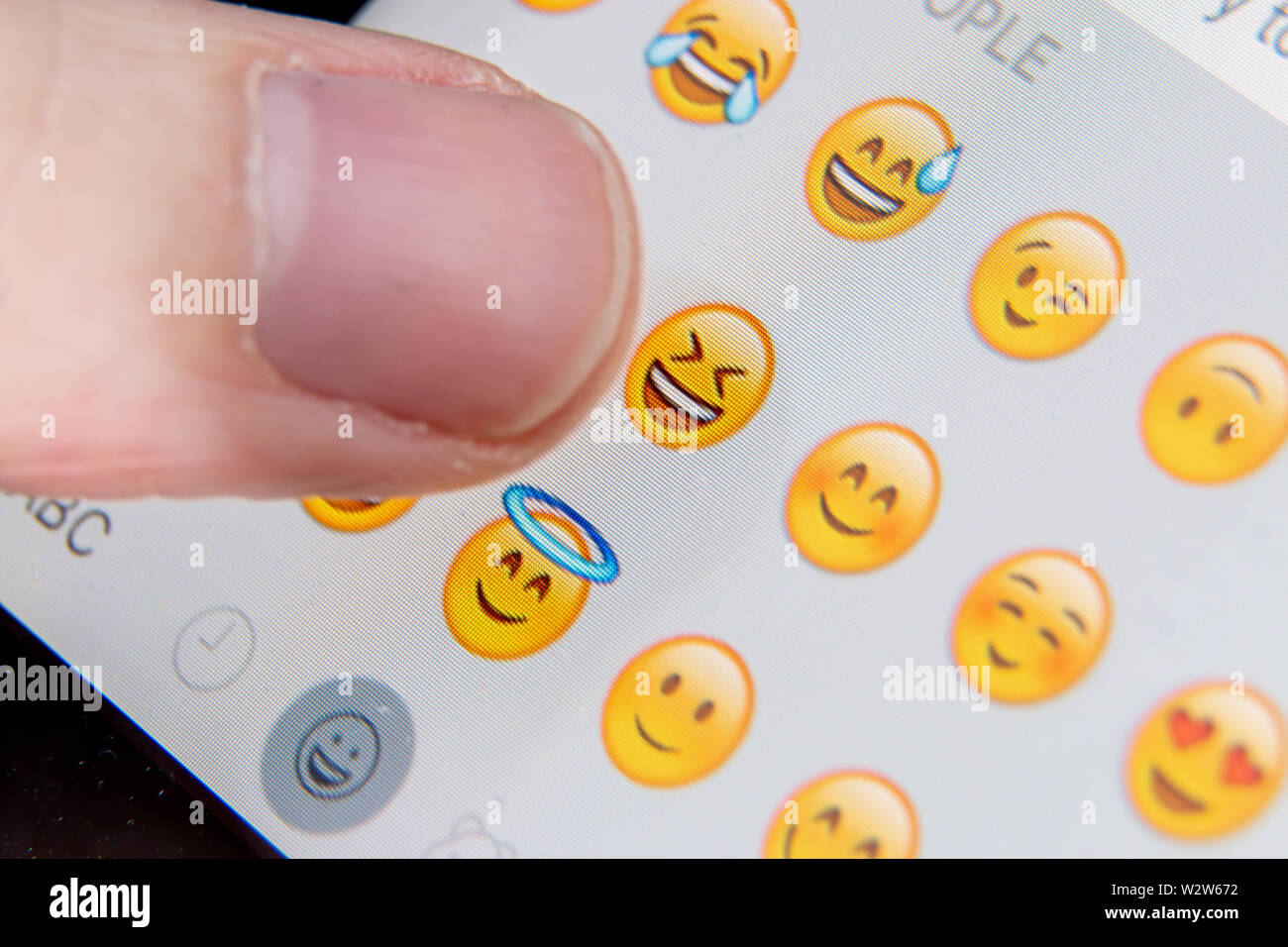 Close up of someone slecting an emoji character Stock Photo