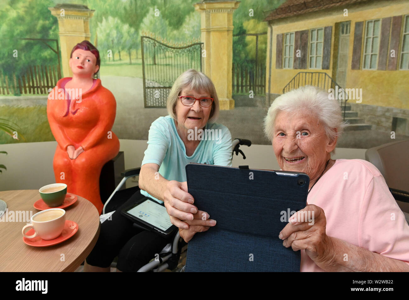 Kassel, Germany. 26th June, 2019. Rosemarie Fischer (l, 81) and Gisela Bossecker (95) photograph the reporters with a tablet in the Käthe-Richter-Haus retirement home. In retirement homes, the Internet had a niche existence. But nursing homes are rethinking - also because their clientele is changing. Credit: Uwe Zucchi/dpa/Alamy Live News Stock Photo