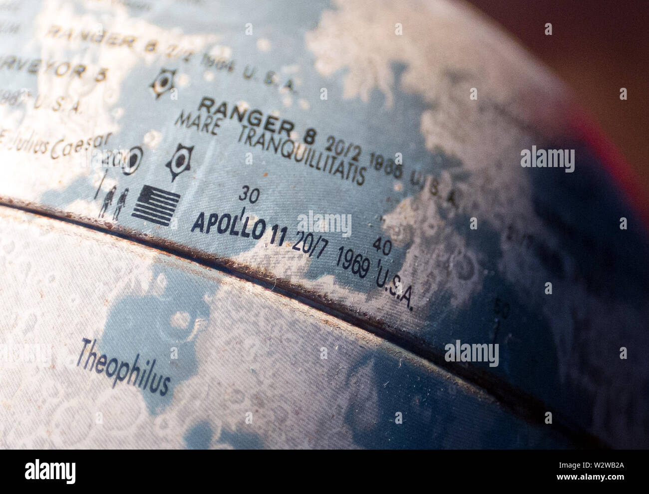 02 July 2019, Germany (German), Berlin: A metal moon globe with a marking  of the Apollo 11 landing site stands in an apartment. July 20, 2019 marks  the 50th anniversary of the