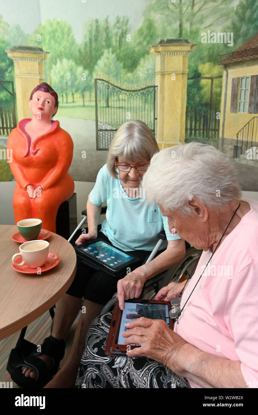 Kassel, Germany. 26th June, 2019. Rosemarie Fischer (l, 81) and Gisela Bossecker (95) deal with their tablet in the Käthe-Richter-Haus retirement home. In retirement homes, the Internet had a niche existence. But nursing homes are rethinking - also because their clientele is changing. Credit: Uwe Zucchi/dpa/Alamy Live News Stock Photo