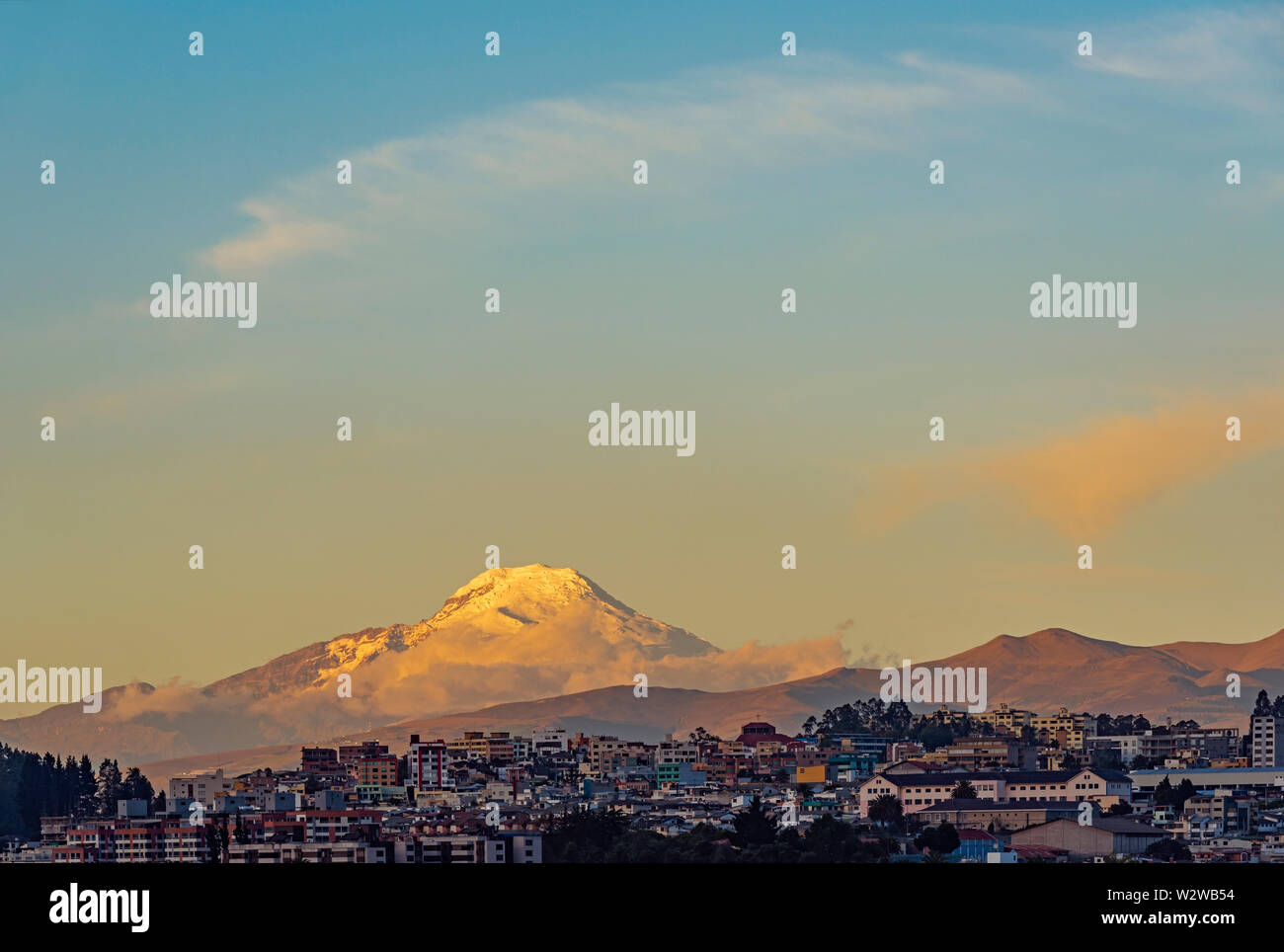 The snowcapped Andes peak of the Cayambe volcano at sunset with the urban skyline of Quito, Ecuador. Stock Photo