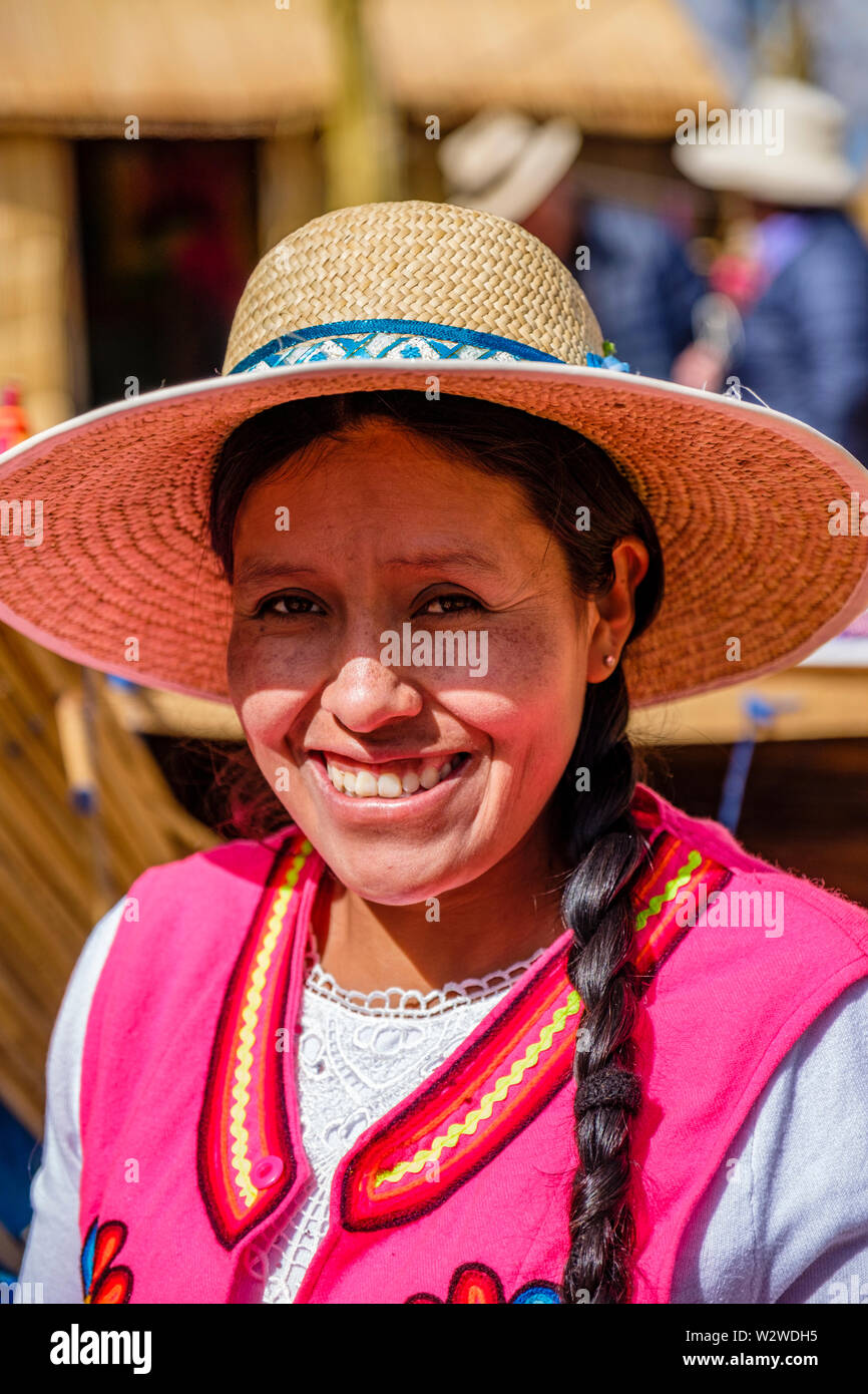 Portrait of a smiling local Peruvian Uru indigenous woman in a totora reed floating island, Uros Floating Islands, Lake Titicaca, Uros, Puno, Peru Stock Photo