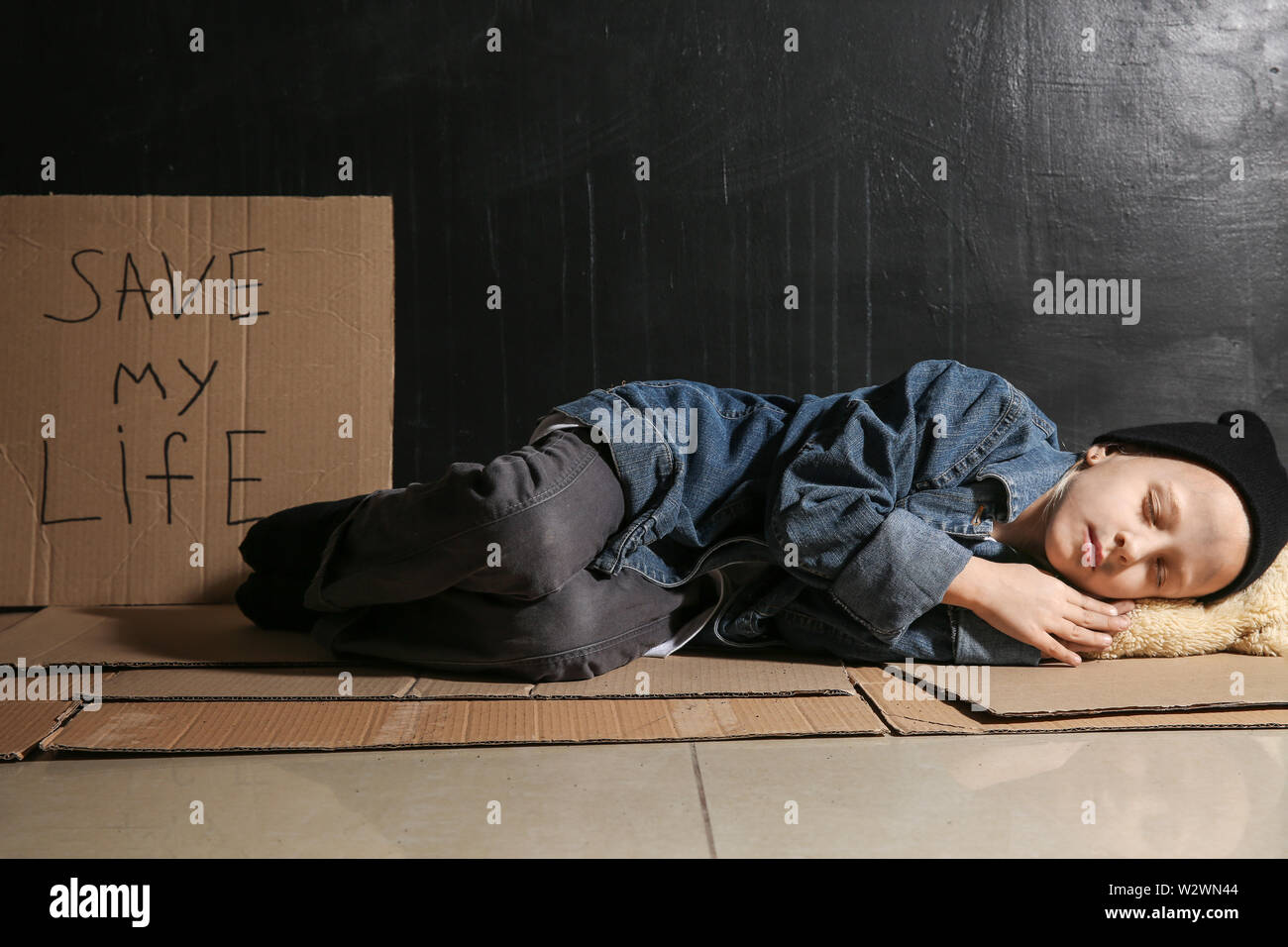 Homeless little girl sleeping on floor near dark wall Stock Photo Alamy