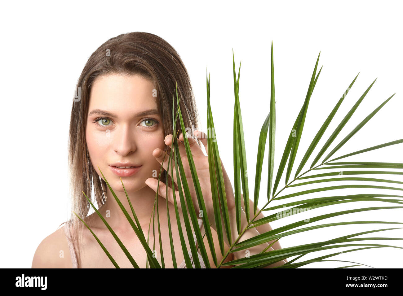 Beautiful young woman with tropical leaf on white background Stock ...