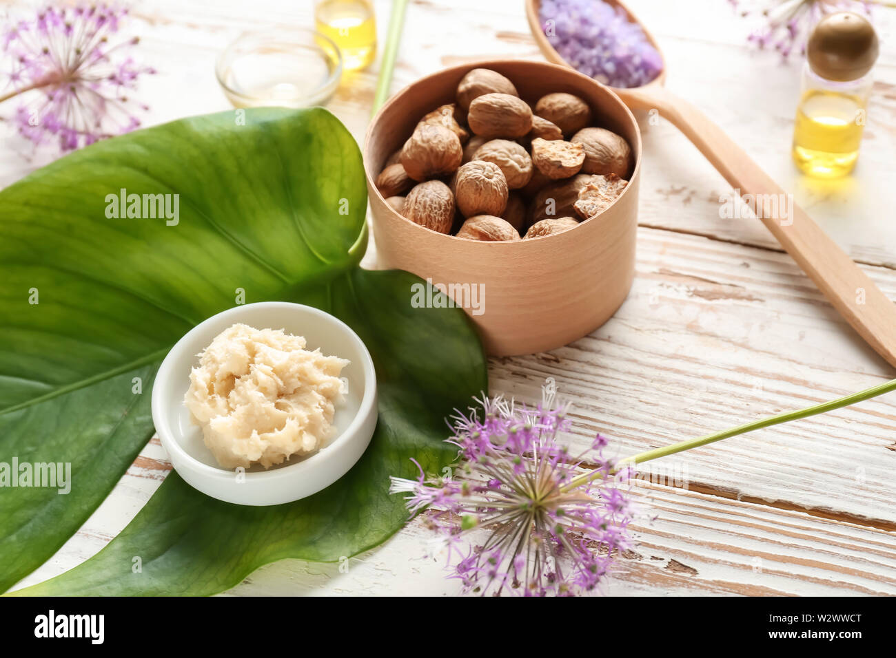 Shea butter with nuts on white wooden background Stock Photo - Alamy