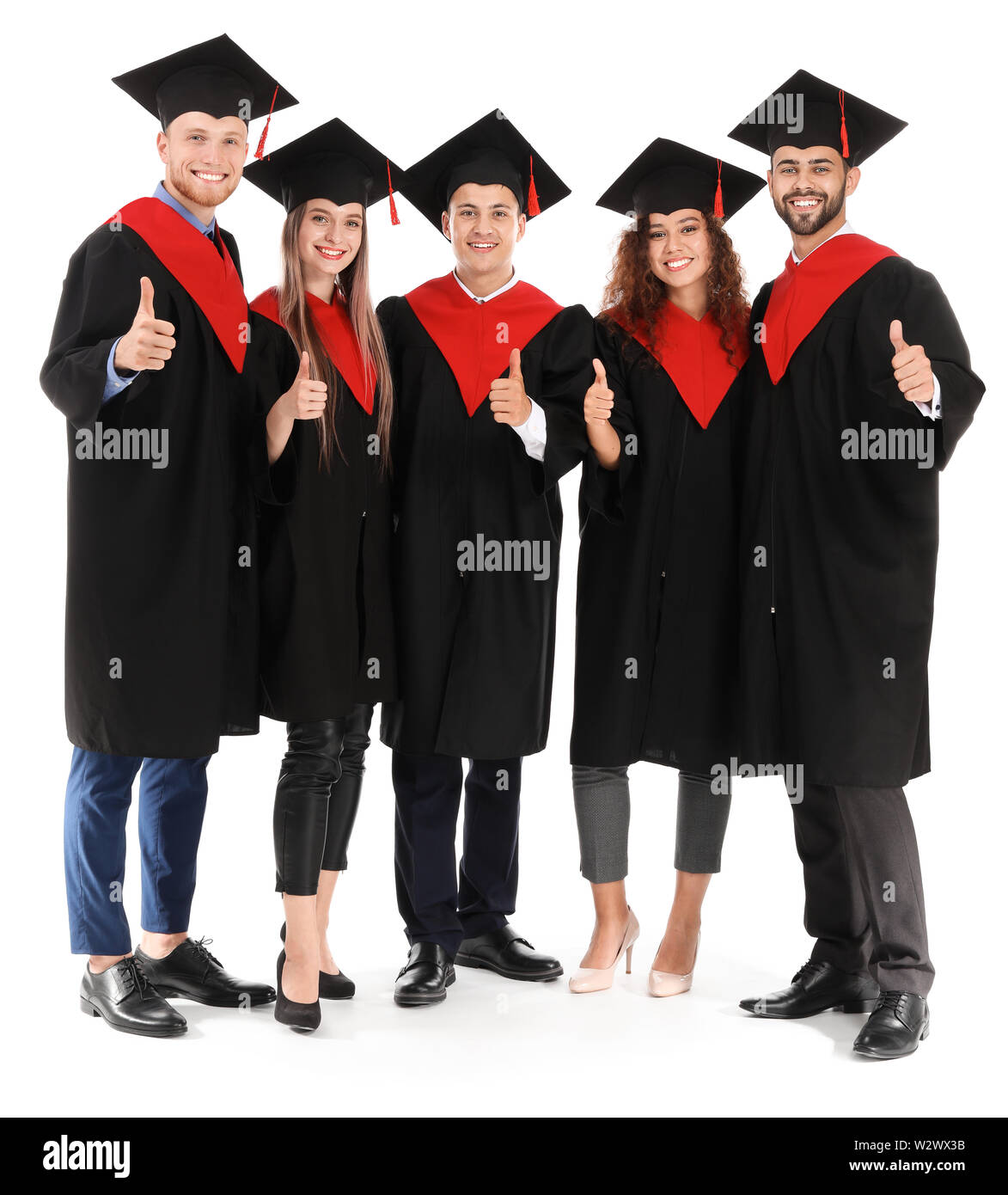 Young students in bachelor robes showing thumb-up on white background ...