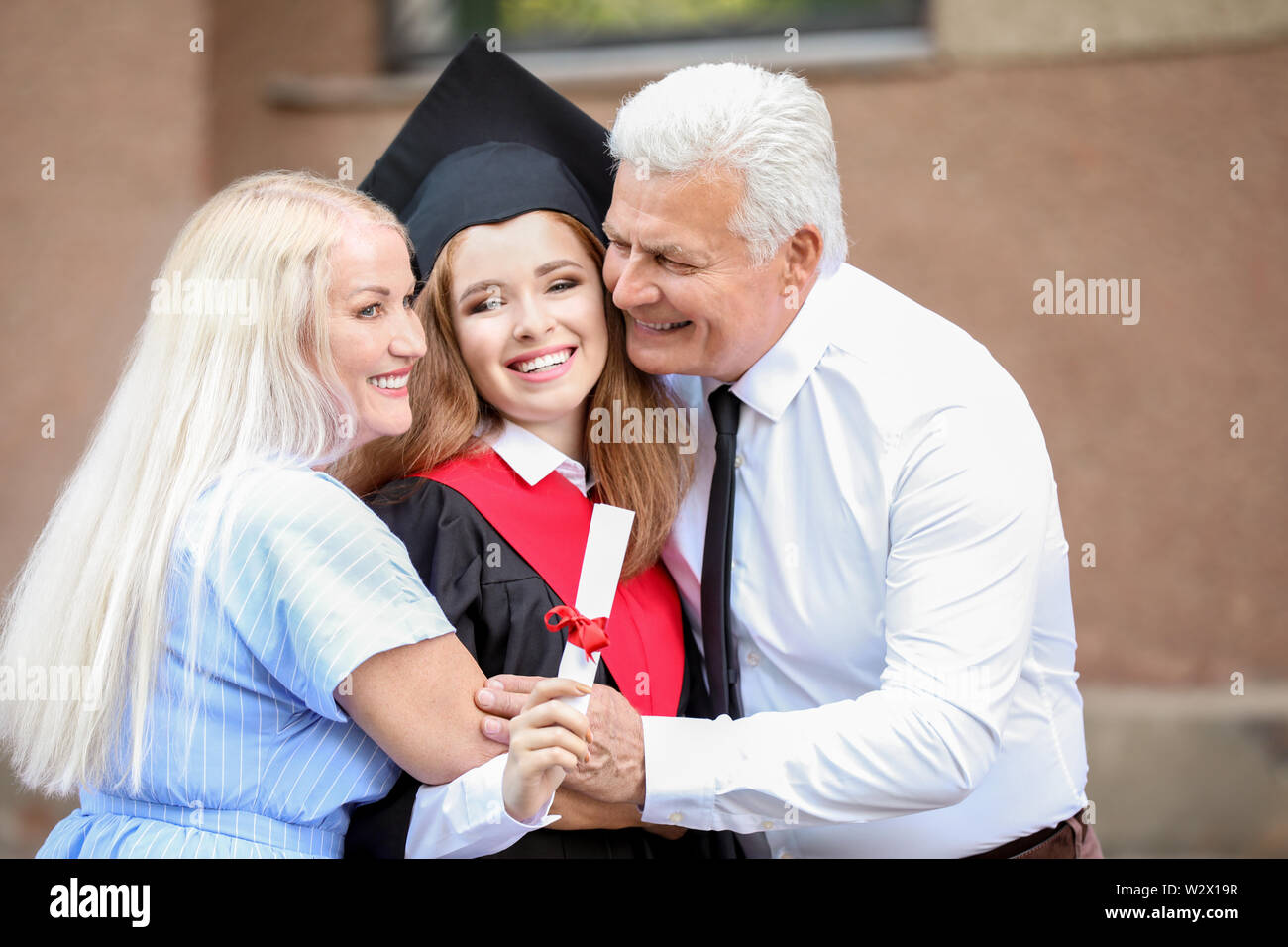 Happy young woman with her parents on graduation day Stock Photo - Alamy