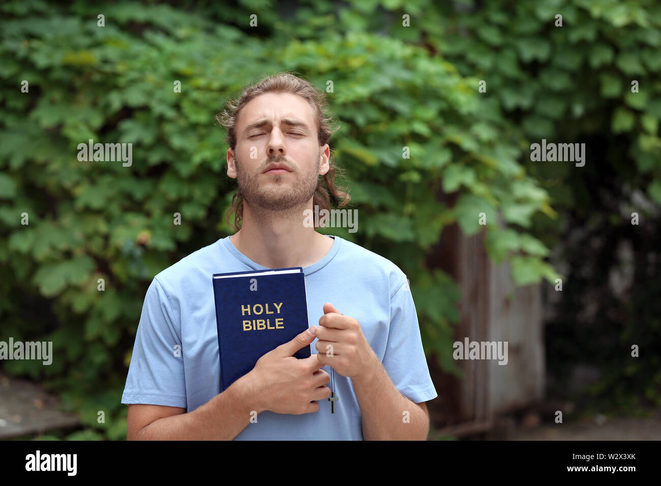 Religious young man praying outdoors Stock Photo Alamy