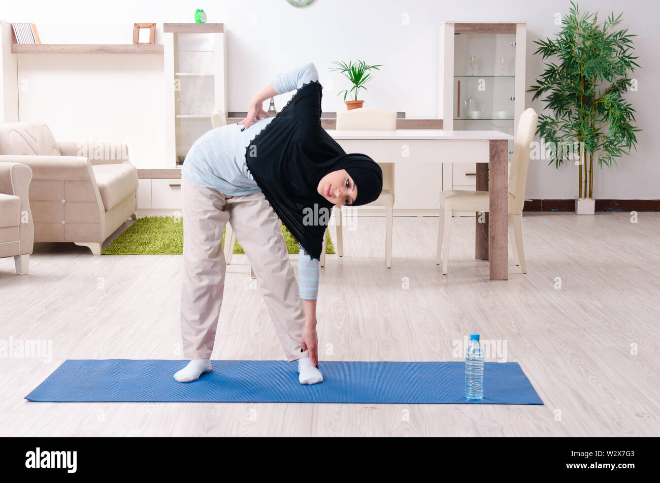 The young woman in hijab doing exercises at home Stock Photo - Alamy