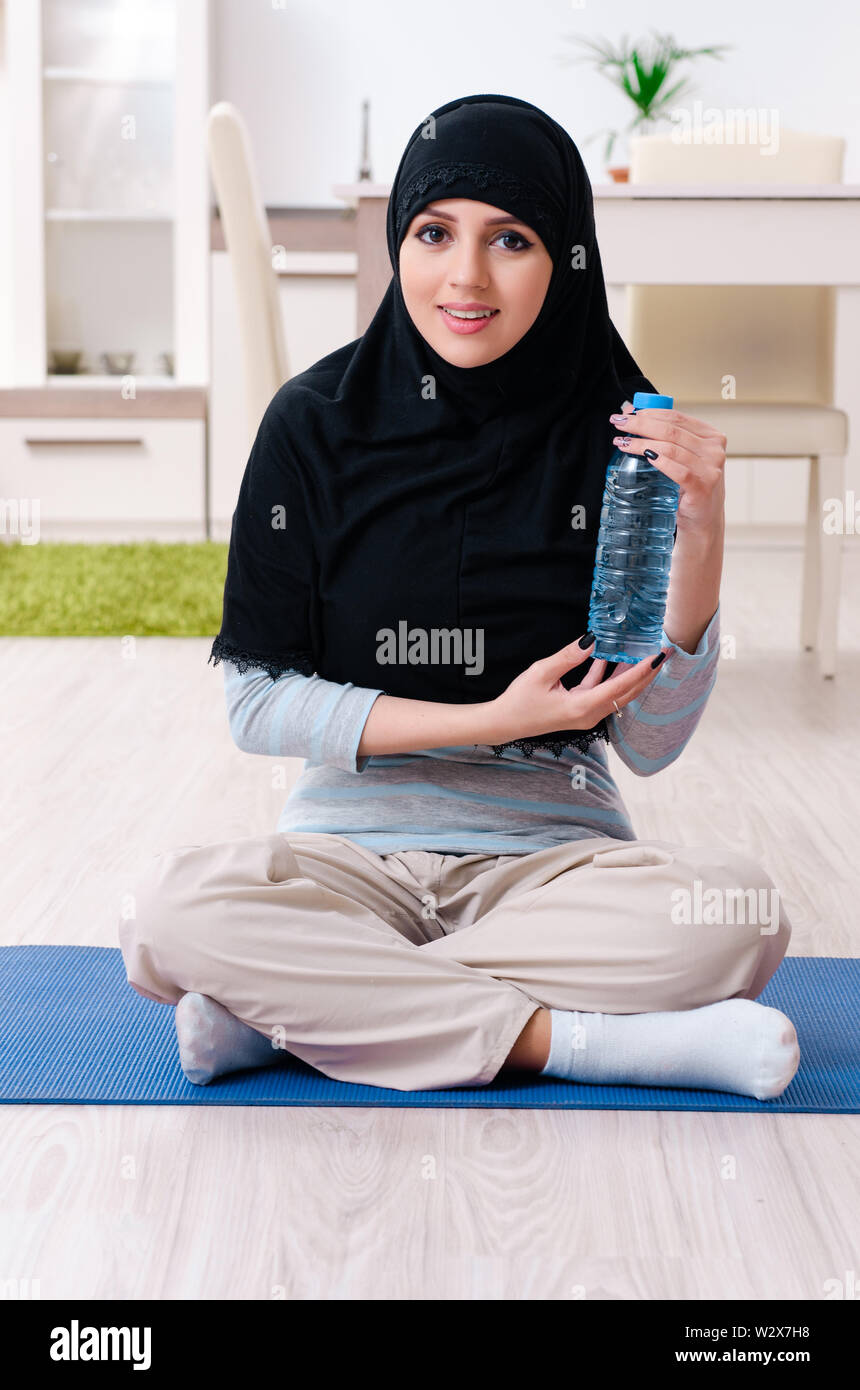 The young woman in hijab doing exercises at home Stock Photo - Alamy