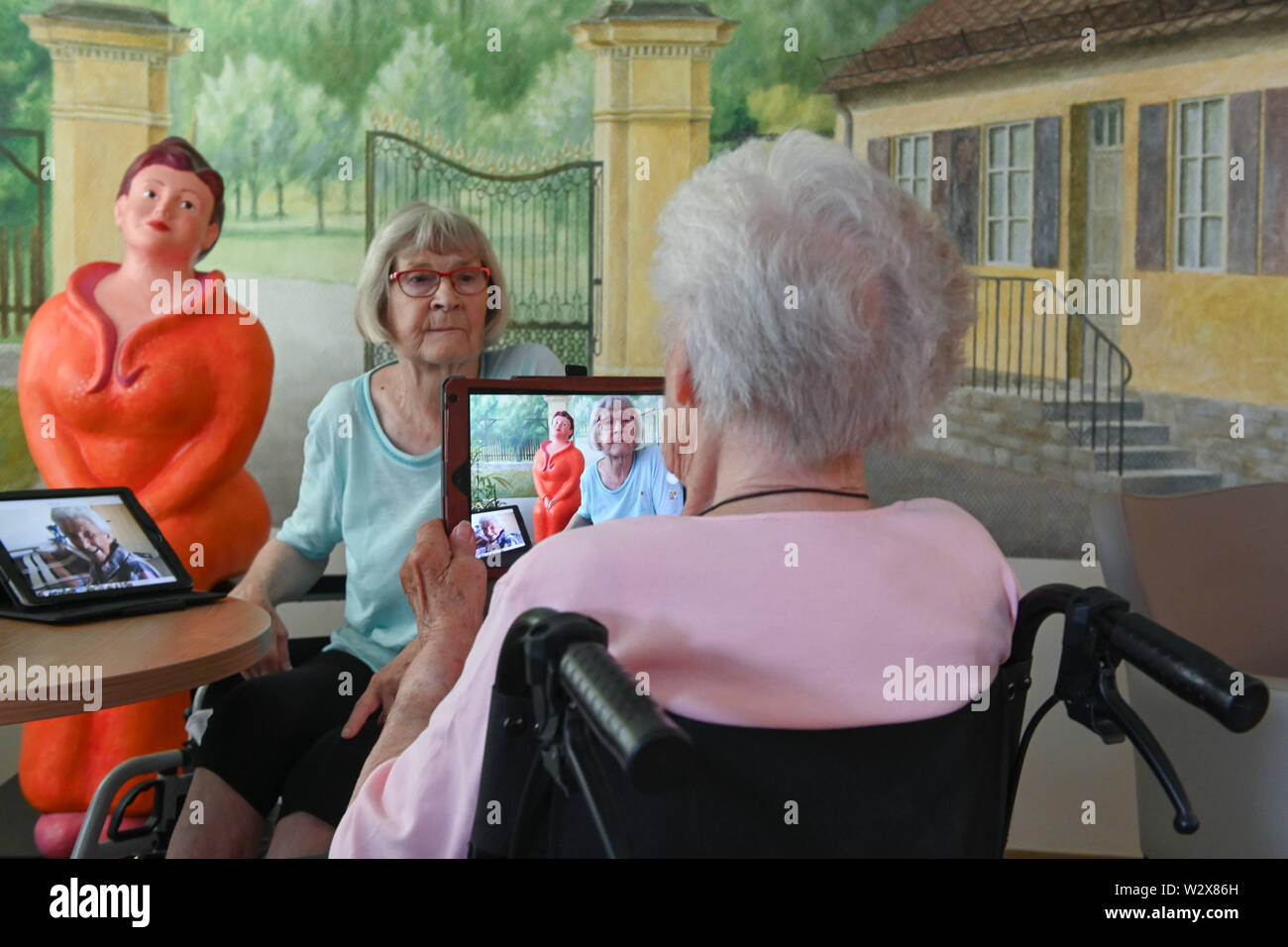 Kassel, Germany. 26th June, 2019. Gisela Bossecker (r, 95) photographs Rosemarie Fischer (81) with her tablet at the Käthe-Richter-Haus retirement home. In retirement homes, the Internet had a niche existence. But nursing homes are rethinking - also because their clientele is changing. Credit: Uwe Zucchi/dpa/Alamy Live News Stock Photo