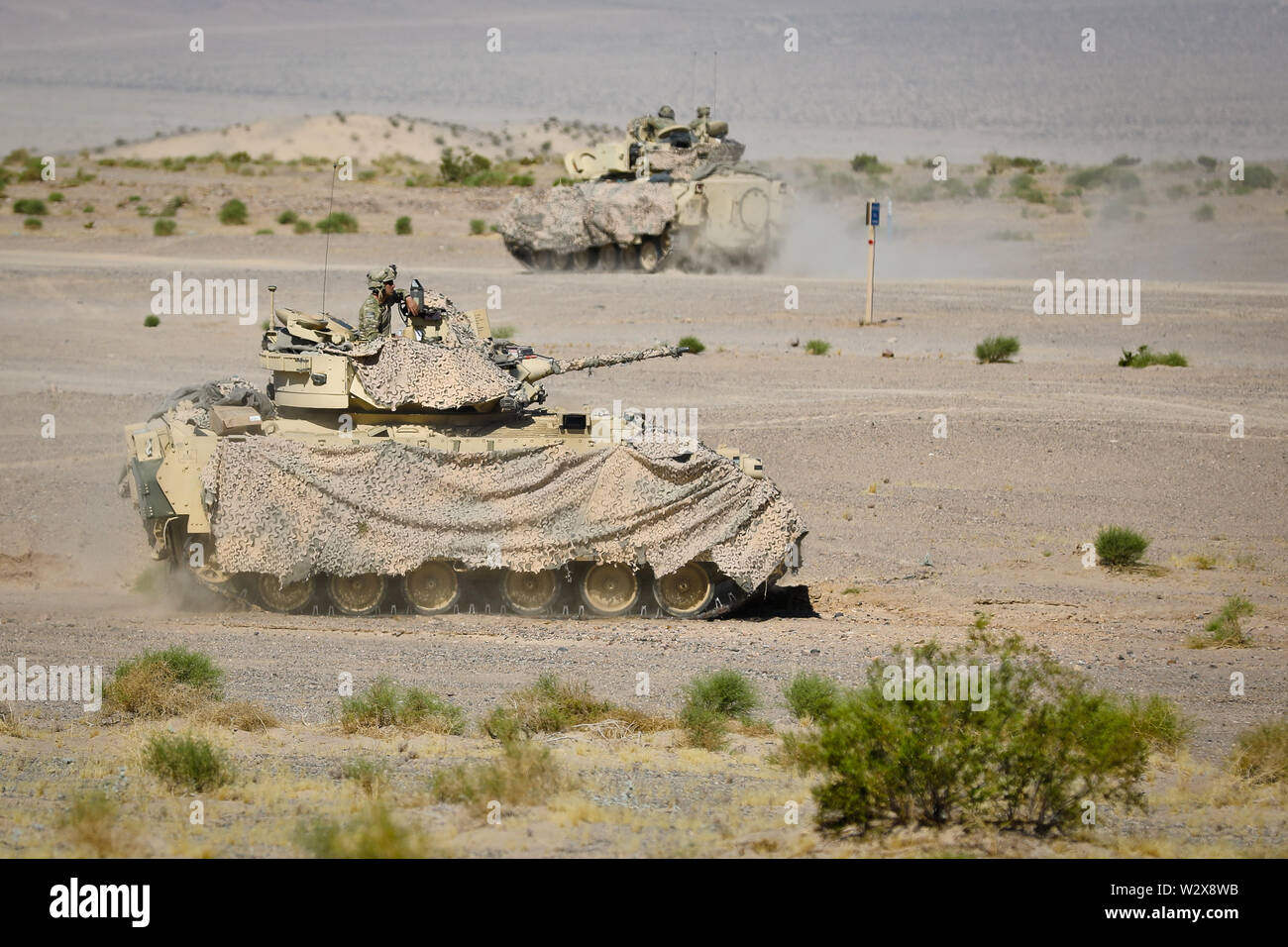 Soldiers of the 1st Squadron, 150th Cavalry Regiment, 30th Armored Brigade Combat Team, West Virginia National Guard, maneuver a Bradley Fighting Vehicle during Operation Hickory Sting at Fort Irwin, California, July 8, 2019. Operation Hickory Sting is a decisive action rotation focused on combined arms maneuver and collective gunnery at the National Training Center, Fort Irwin, California, in order to validate the capabilities of the 30th in the training environment and provide a globally responsive brigade ready to deploy, fight and win. (U.S. Army National Guard Photo by Sgt. Jamar Marcel P Stock Photo