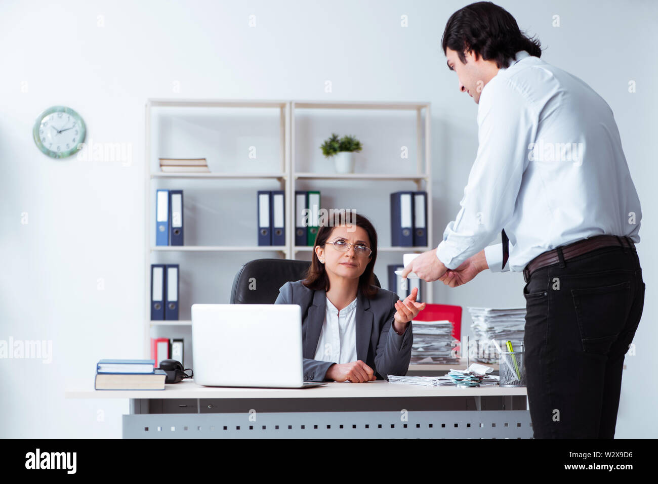 The old female boss and young male employee in the office Stock Photo -  Alamy