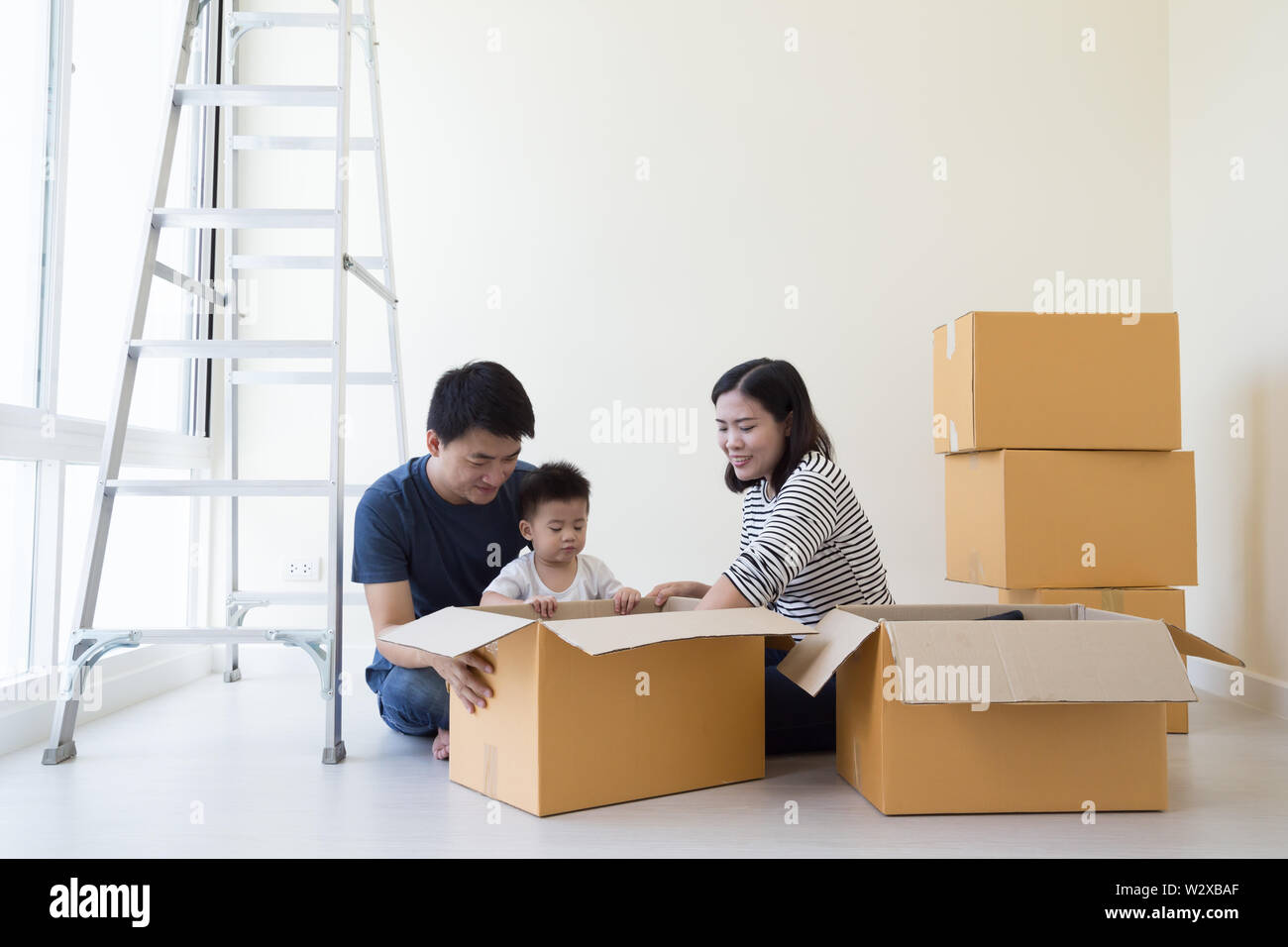 Family Unpacking Boxes In New Home On Moving Day Happy Father